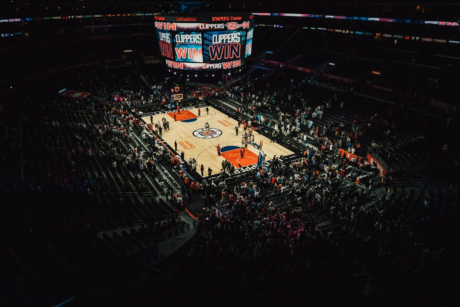 A packed arena crowd watching a game under stadium lights at night